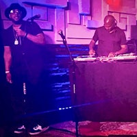 two men standing in front of a dj booth