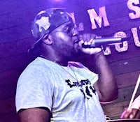 a man singing into a microphone in front of a stage